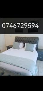 a large bed in a room with a clock on the wall at Hatfield, Grosvenor Private apartment. in Pretoria