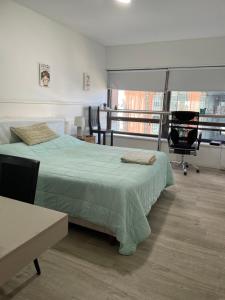 a bedroom with a bed and a desk and a chair at Maipo 1501 in Buenos Aires