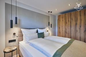 1 dormitorio con cama blanca y pared de madera en Chalet Weidentraum en Oberstaufen