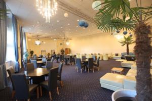 a dining room with tables and chairs in a room at Carea Harz Hotel Allrode in Allrode