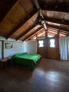 ein Schlafzimmer mit einem grünen Bett in einem Zimmer in der Unterkunft Huecubu suites in San Miguel del Monte