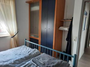 a small bedroom with a bed and a closet at Ferienwohnung Marina Cux in Cuxhaven
