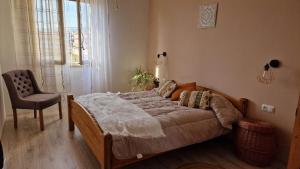 a bedroom with a bed with a chair and a window at BOHO ROOMS MARTA in Priolo Gargallo