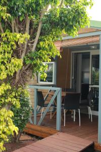 a house with a table and chairs on a deck at Les bungalows du chateau d'Ô in Petite Île