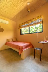 a small bedroom with a bed and a window at Casita Chinola - Playa El Encuentro in Bombita