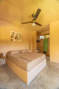 a bedroom with a bed with a ceiling fan at Casita Chinola - Playa El Encuentro in Bombita