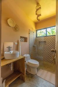 a bathroom with a toilet and a sink and a shower at Casita Chinola - Playa El Encuentro in Bombita
