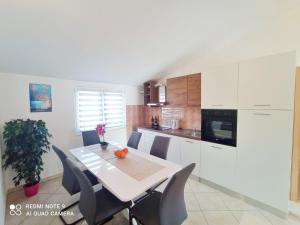 a kitchen with a table and chairs in a room at Apartman Mia with pool1 in Split