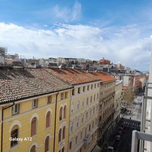 un edificio amarillo con techos de teja en una ciudad en Trieste Mia Rooms en Trieste