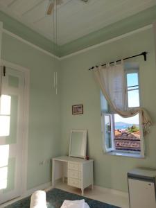 a room with a mirror and a table and a window at Eolos House Cunda in Ayvalık