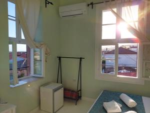 sypialnia z 2 oknami i łóżkiem z ręcznikami w obiekcie Eolos House Cunda w mieście Ayvalık