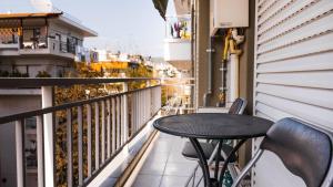 uma varanda com uma mesa e cadeiras em Soleado, Nilie Hospitality MGMT em Tessalônica