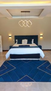 a bedroom with a large bed with a blue rug at WHITE SHARK RESORT in Ponta do Ouro