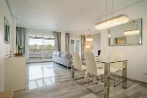 a dining room and living room with a table and chairs at El Lago de Los Arqueros 2 bedrooms penthouse en Benahavis in Benahavís