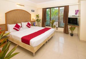 a bedroom with a large bed with red pillows at Octave Bund Garden in Pune