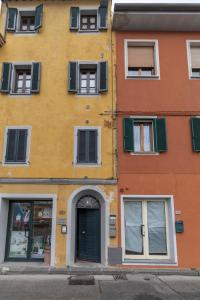 um edifício amarelo com janelas verdes fechadas e uma porta em Italian Experience-Il Borgo Apartment em Bientina