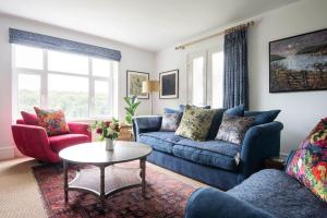 uma sala de estar com dois sofás azuis e uma mesa em Asman em Salcombe