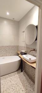 y baño con bañera y lavamanos. en L'Oustal de Papet, en Ferrals-lès-Corbières