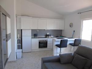 una cocina con armarios blancos y un sofá en una habitación en 2 bed Apartment Villamartin with communal pool, en San Miguel de Salinas