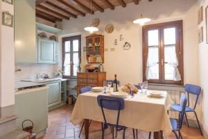 uma cozinha com uma mesa com cadeiras azuis num quarto em Italian Experience-Il Borgo Apartment em Bientina