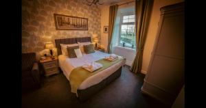 Ensuite Bed And Breakfast Rooms At The Ring Pub في Gwredog: غرفة نوم عليها سرير وفوط