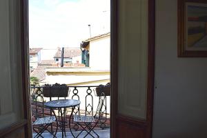 uma porta aberta para uma varanda com uma mesa e cadeiras em Florence Heart B&B em Florença