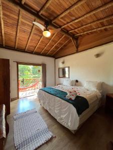 a bedroom with a large bed with a wooden ceiling at A Mi Manera Pousada , cerveja própria e Bistrô ! in Brumadinho