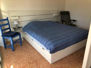 1 cama con edredón azul y silla azul en Studio des îles en Cavalaire-sur-Mer