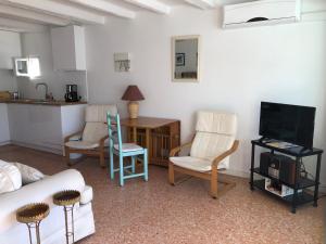 a living room with a couch and chairs and a kitchen at Studio des îles in Cavalaire-sur-Mer