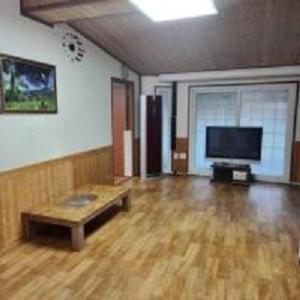 a living room with a wooden floor and a flat screen tv at Hongcheon fence house in Hongcheon