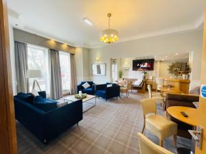 a living room with couches and a dining room at The Westlynne Hotel & Apartments in Manchester