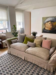 Beautiful Kensington flat في لندن: أريكة في غرفة معيشة مع لوحة على الحائط