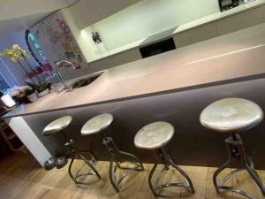 three bar stools in front of a kitchen counter at Beautiful Kensington flat in London