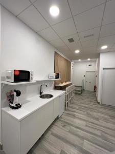 um quarto com uma cozinha com um lavatório e um micro-ondas em CH TANEZ CAROLINA a em Madri