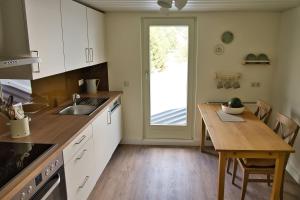 - une cuisine avec une table en bois et une table à manger dans l'établissement Adesso - Ferienwohnung im Schwarzwald, à Leinstetten