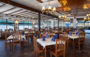 a dining room with tables and chairs and windows at Medplaya Hotel Vistamar Costa Dorada in Hospitalet de l'Infant