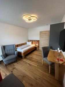 een slaapkamer met een bed en 2 stoelen en een tafel bij Hotel garni Alpengruss in Garmisch-Partenkirchen