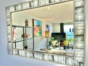 a living room with a mirror on the wall at Stunning Sea View Two Bed Apartment - With Balcony in Bournemouth