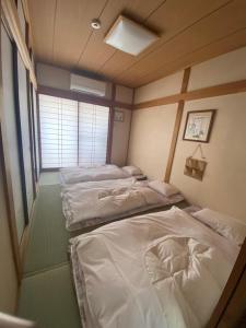 a room with three beds in it at 澄の宿 京都伏见稻荷別邸 京阪电车伏见稻荷站徒步1分钟 jr电车稻荷站徒步4分钟 in Kyoto