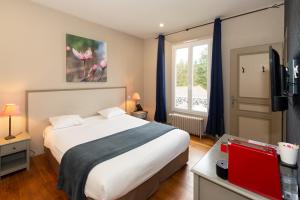 a bedroom with a large bed and a window at Le Gingko - Hotel du Golf Parc Robert Hersant in La Chaussée-dʼIvry