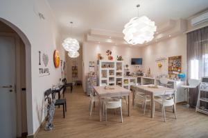 uma sala de jantar com mesas, cadeiras e luzes em Holidays Lecce em Lecce