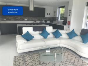 a living room with a white couch and blue pillows at Ocean View Apartments in Looe