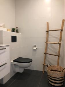 een badkamer met een toilet en een zwarte toiletbril bij Life Contains Beautiful Things in Almere