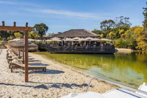 a restaurant with chairs and umbrellas on the water at Quinta do Lago, Victory Village N 63 in Almancil
