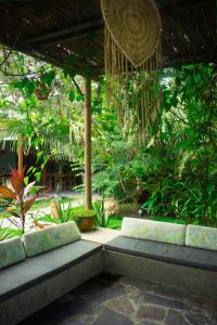 un patio avec deux bancs dans un jardin dans l'établissement Ekaa Hotel, à Palomino