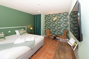 1 dormitorio con 1 cama y TV. en Le Gingko - Hotel du Golf Parc Robert Hersant, en La Chaussée-dʼIvry