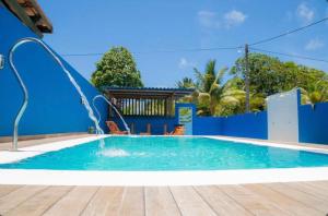 a swimming pool with a blue wall and a blue at Pousada Serra Mares in Ilhéus