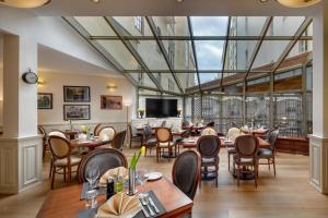 a restaurant with tables and chairs and a large glass ceiling at Boutique Hotel Seven Days in Prague