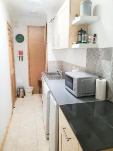 a kitchen with a sink and a microwave on a counter at Little Dragons in Parkstone