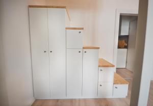 a white closet with white cabinets and a shelf at Apartmenthaus Fritz Reuter in Schwerin